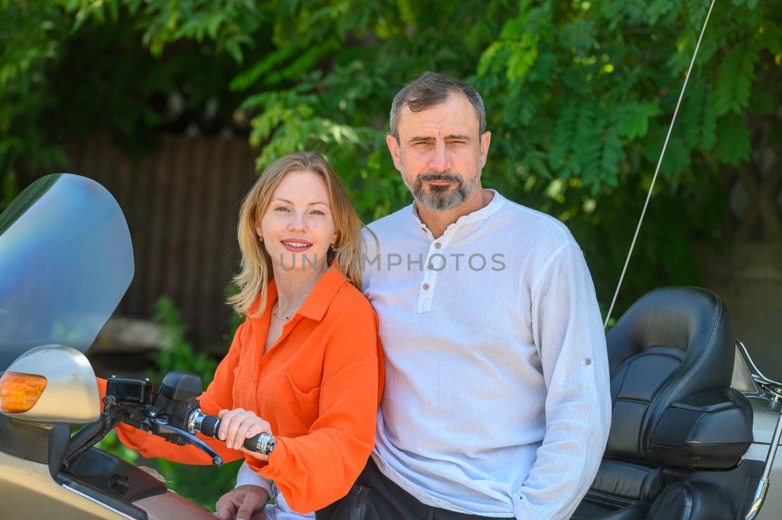 happy husband and wife sitting on a motorcycle