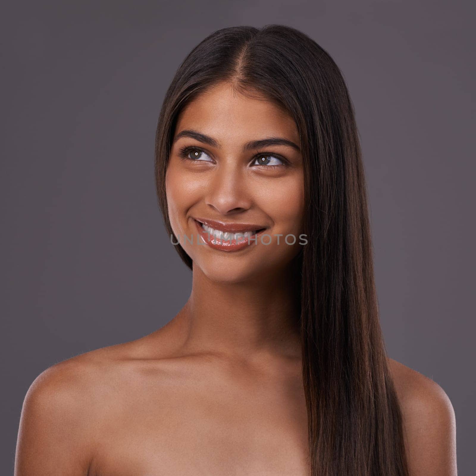 Beauty, hair and face of woman on gray background for healthy texture, wellness and shine. Haircare, hairdresser and happy person with long hairstyle for salon products, cosmetics and glow in studio.