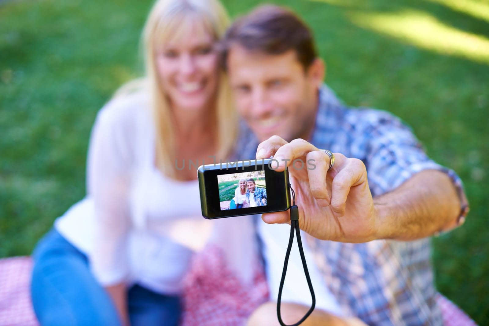 Camera, screen and couple in a park, date and happiness with love and romance with a selfie in nature. Photograph, outdoor and memory with man and woman with marriage and relationship with sunshine.