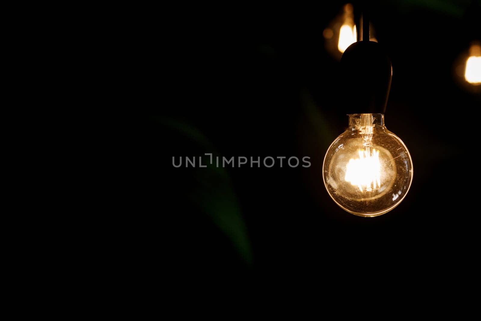 Classic Edison light bulb on black background with space for text