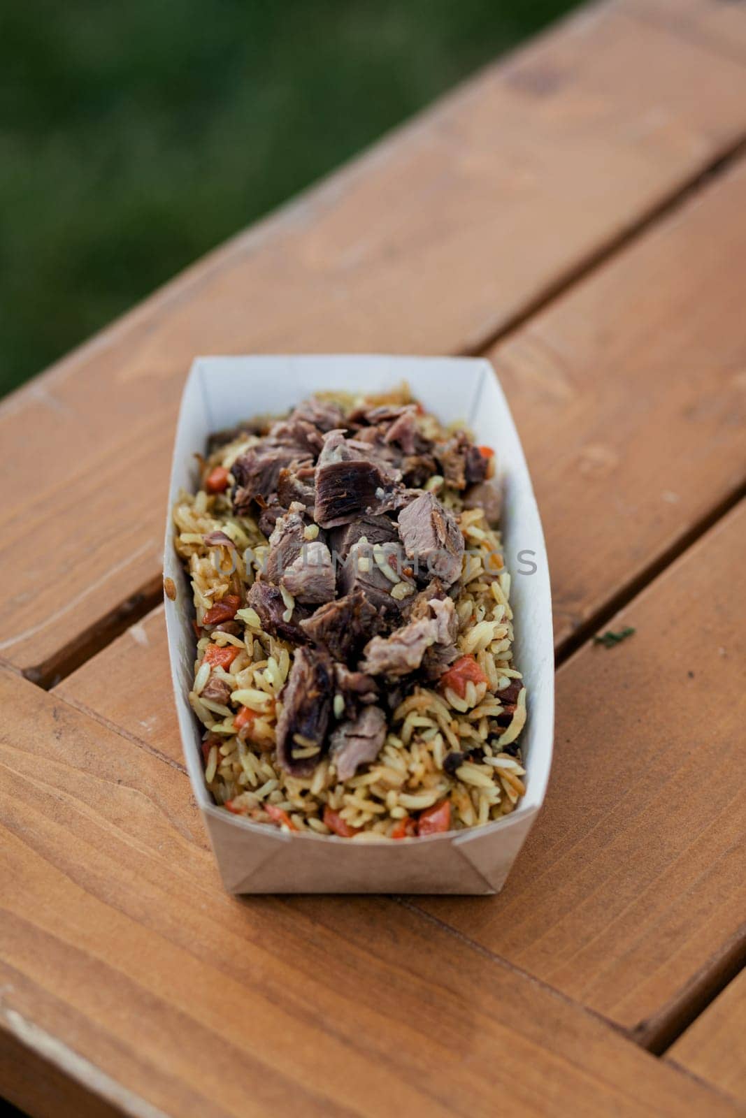 Pilaf or rice with spices with beef. Nutritious lunch, or dinner in a disposable box. Street food