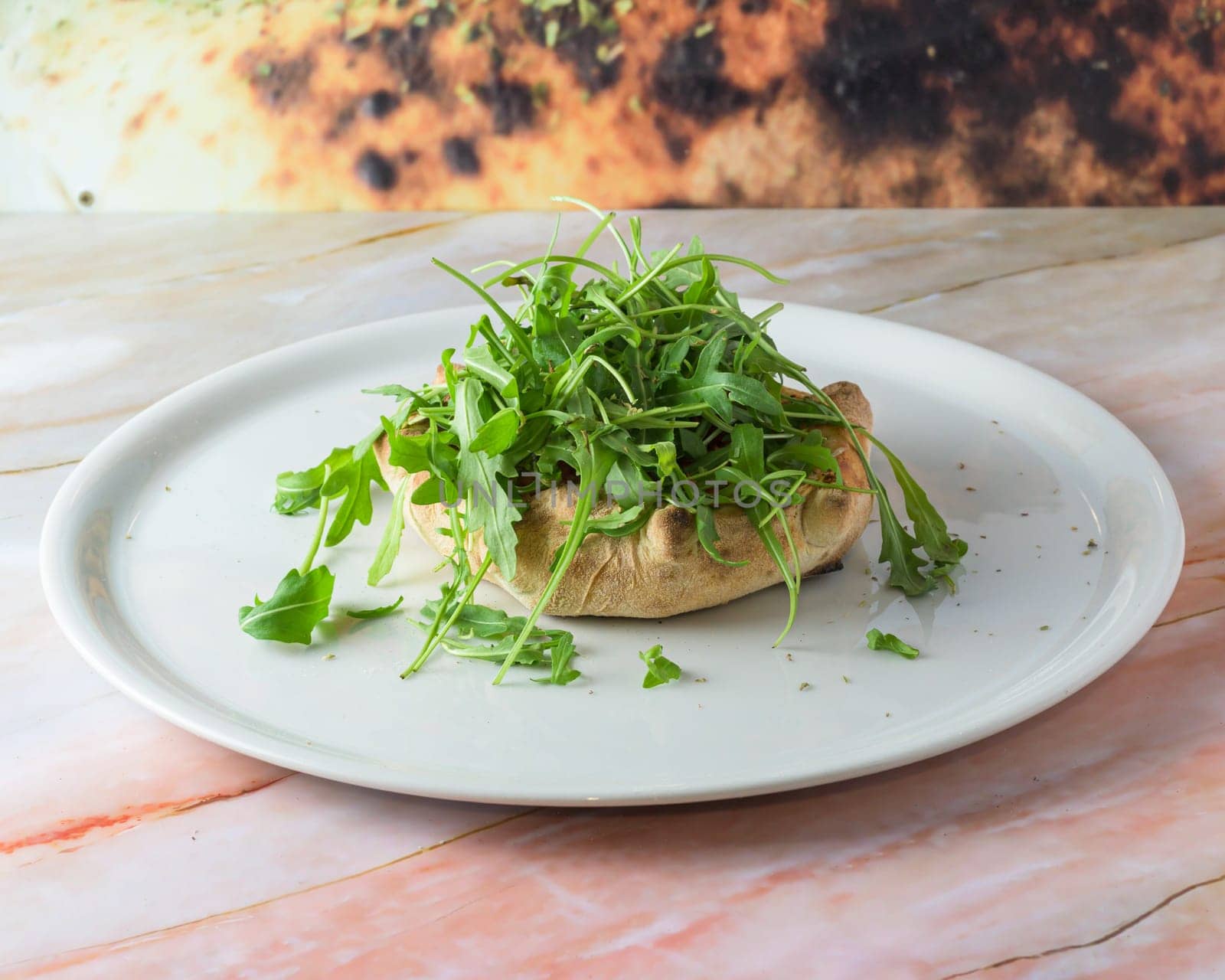 Fugazzeta Argentinian Stuffed Pizza is filled with a layer of mozzarella cheese with sliced onions and even more cheese on top closeup in the plate on the wooden table. Horizontal top view from above by carlosviv