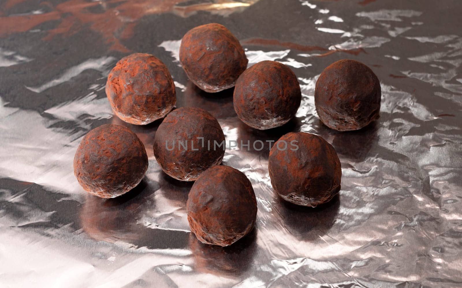 Flat Lay Vegan Raw Sweet Balls made of Organic Cocoa beans With Dry Citrus Fruits on Gray Foil. Closeup. Horizontal Plane. Healthy Food, Dessert High quality photo