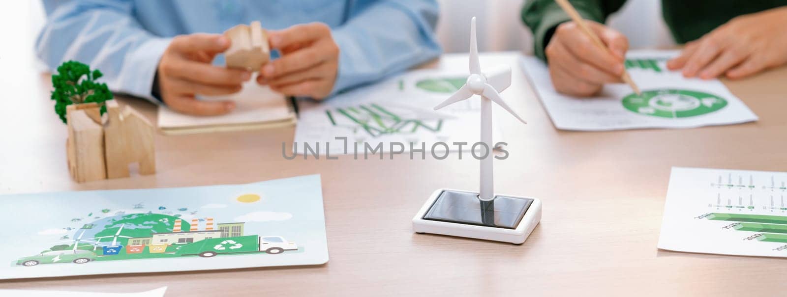 Business people invest in green business plan at meeting room on table with house model and wind mill placed represented eco house and renewable energy. Closeup. Delineation.