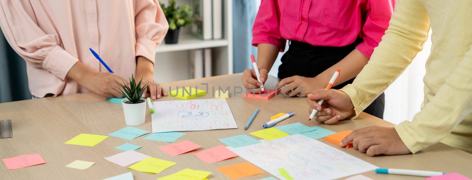 Young business group brainstorms ideas on colorful sticky notes. Variegated. by biancoblue