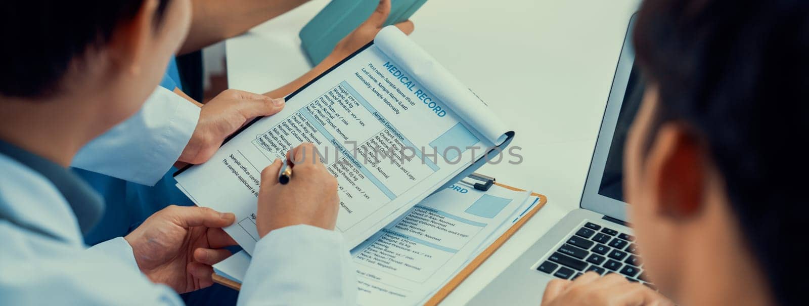 Professional various team of medical working and planning medical treatment at hospital table together. Teamwork lead to successful illness and sickness treatment. Panorama Rigid