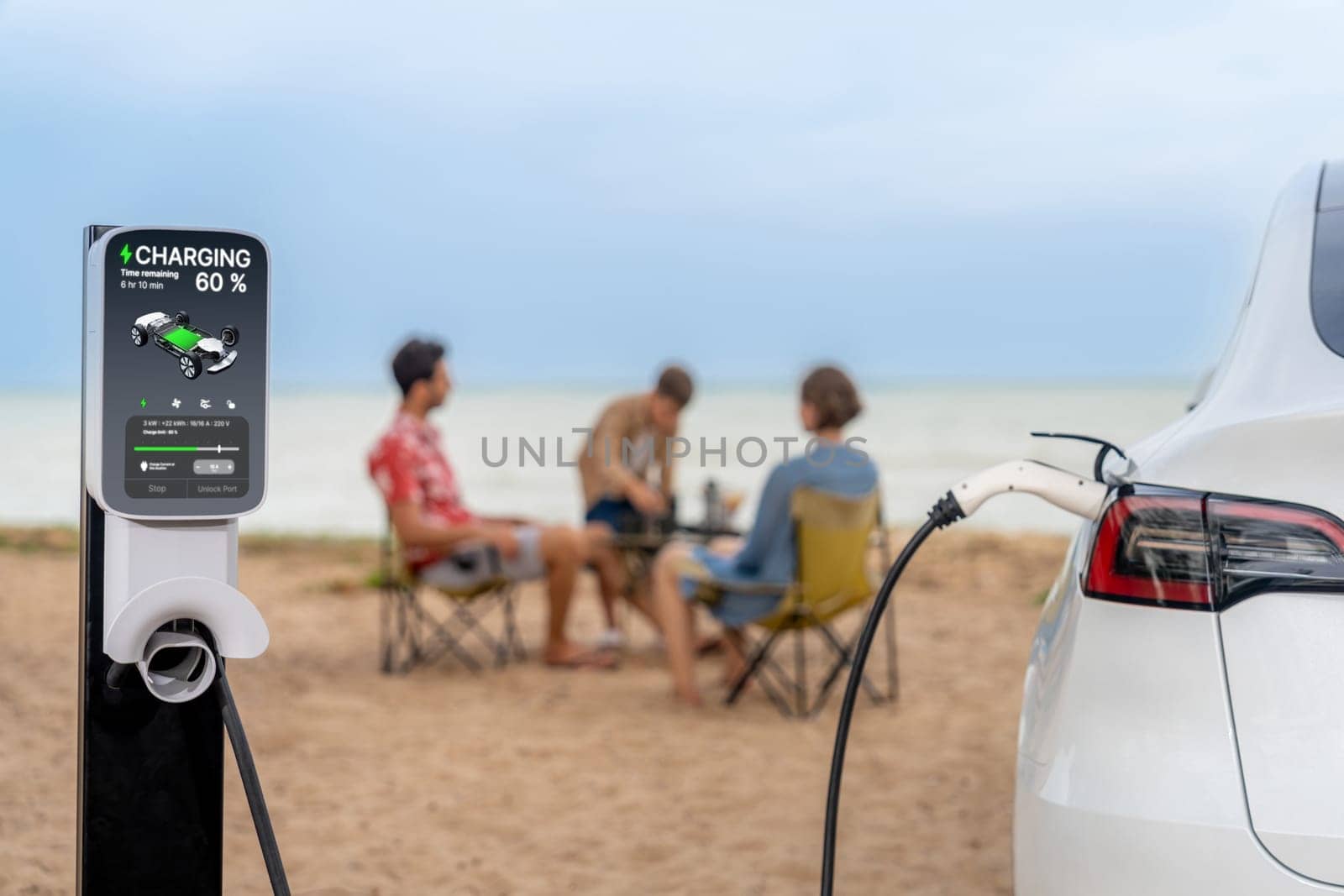 Alternative family vacation trip traveling by the beach with electric car recharging battery from EV charging station with blurred family enjoying the seascape background. Perpetual