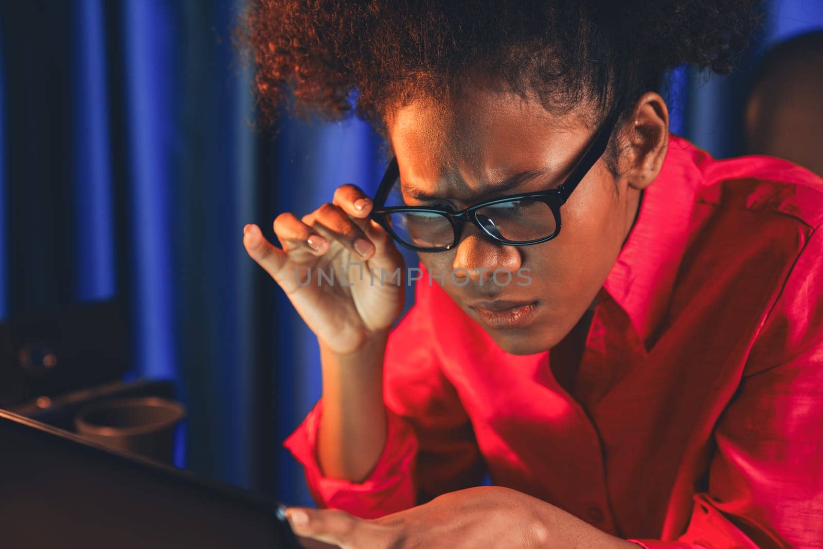 African woman businesswoman or blogger wearing pink shirt with serious face, looking and focusing on screen laptop with struggle project. Concept of stressful expression at work from home. Tastemaker.