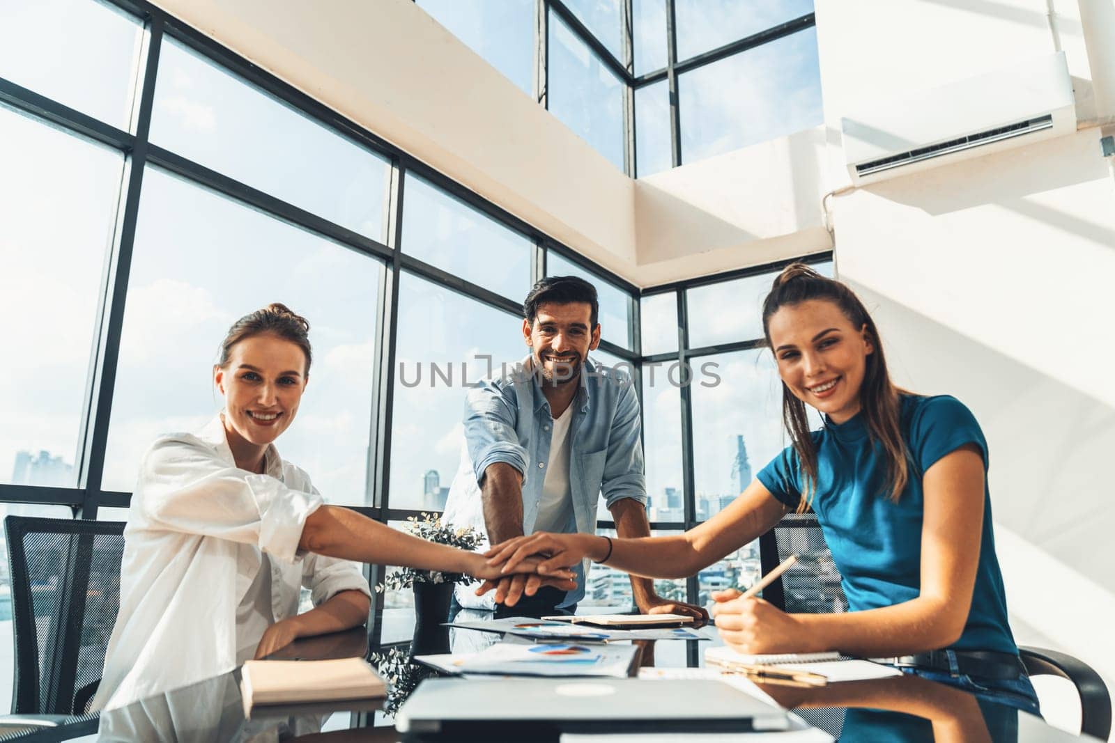 Group of skilled businesspeople putting hands together at modern office.Happy smart business team working together. Represented unity, love, team, working together, partnership, work place. Tracery.