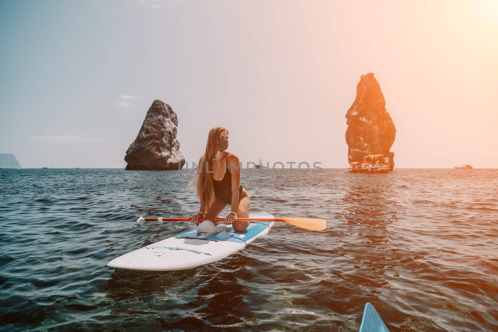 Woman sea sup. Close up portrait of happy young caucasian woman with long hair looking at camera and smiling. Cute woman portrait in bikini posing on sup board in the sea by panophotograph