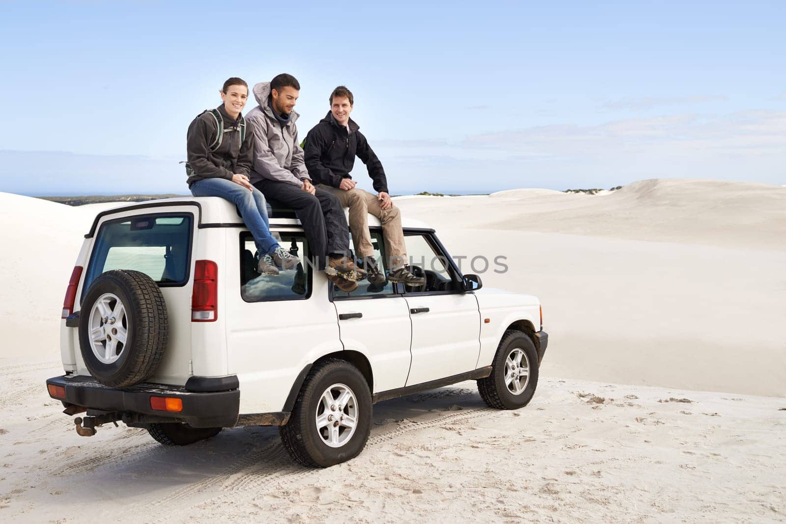 Car, adventure and friends sitting on roof for road trip break, travel and off road drive in sand dune. Relax, transportation and people in nature for getaway, summer vacation and journey in Mexico.