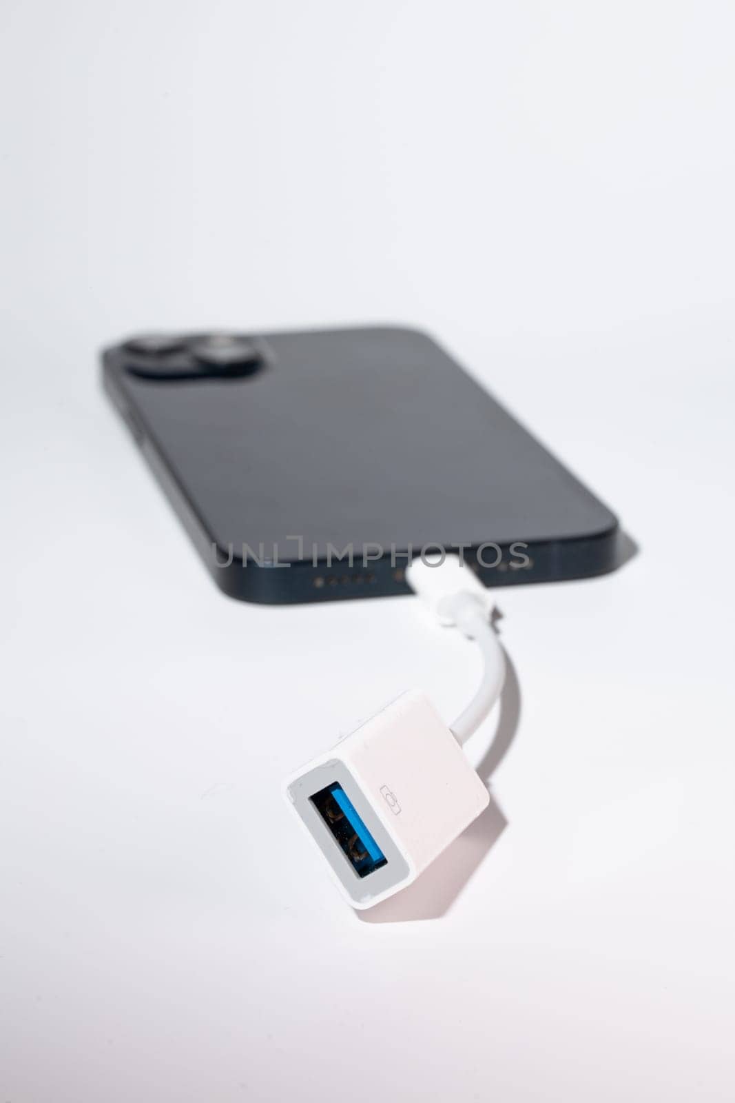 A smartphone connected to a USB adapter as a portable communication device for port-based data transfer by Pukhovskiy