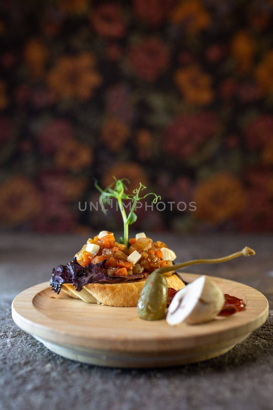 Rustic wooden plate with open faced sandwich with beef tenderloin and roasted mushrooms, garnished with fresh sprouts.