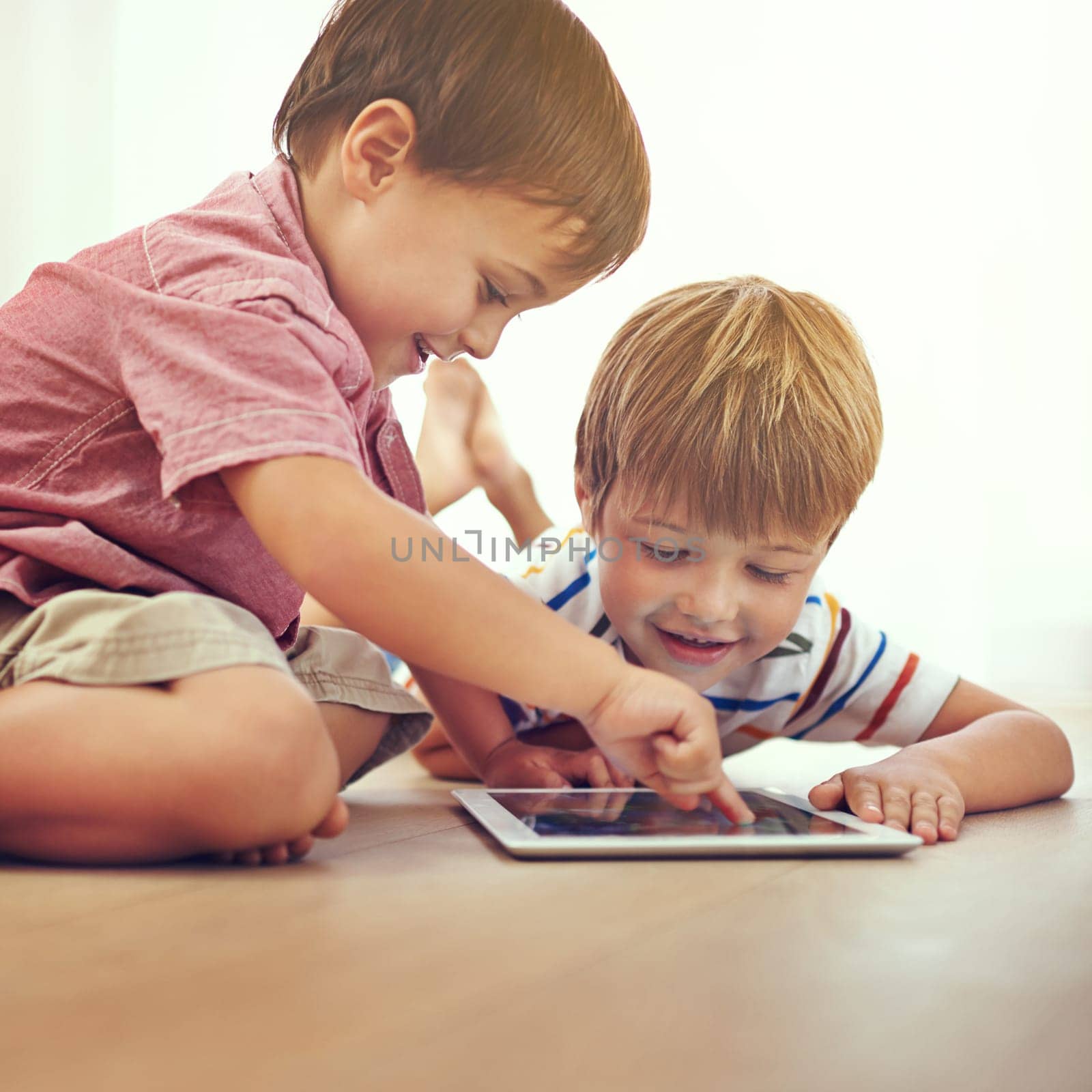 Children, siblings and tablet on a floor with cartoon, gaming or streaming movie at home. Digital, learning and boy kids in house for google it, search or ebook storytelling, app or netflix and chill.