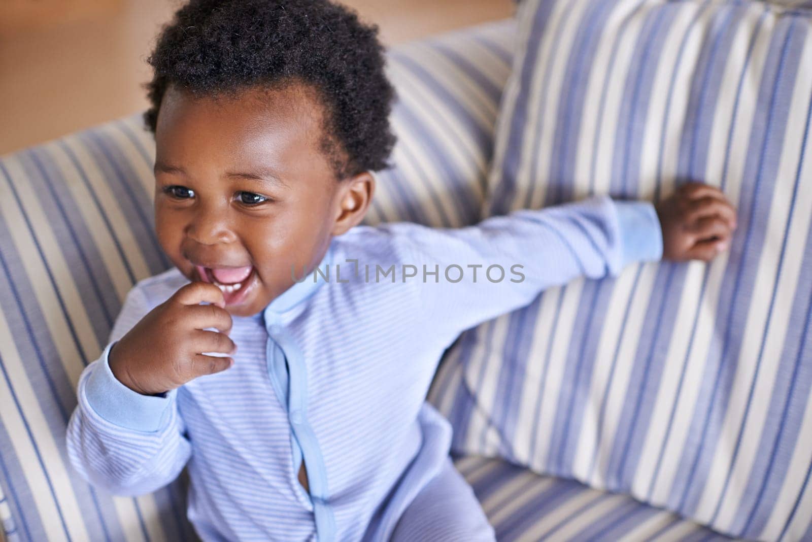 Baby, smile or sofa as play, fun or game for leisure and playing, growth as relax, learn or humor. Excited, black boy child or laugh as curious confidence for motor skill coordination or development.