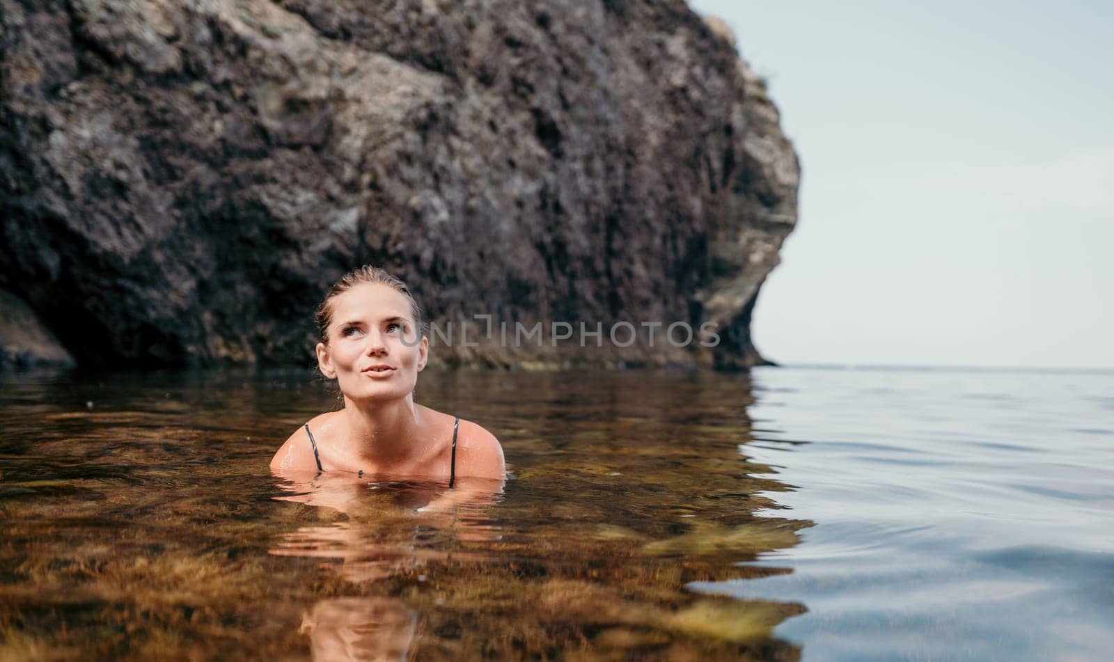 Woman travel sea. Happy tourist enjoy taking picture outdoors for memories. Woman traveler swim in the sea bay with mountains, sharing travel adventure journey by panophotograph