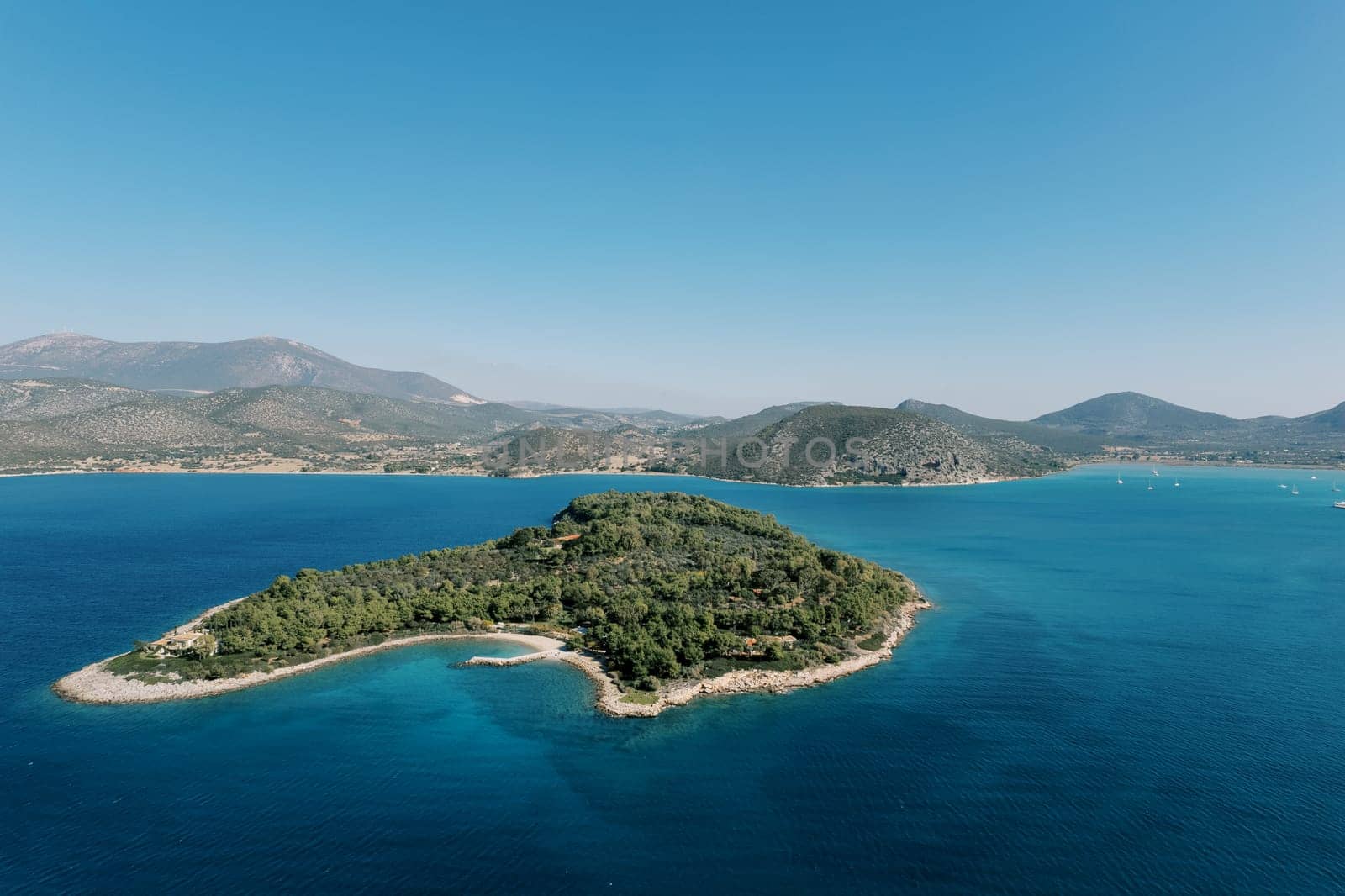 Koronida Argolis island in the Mediterranean Sea against the backdrop of mountains. Greece. High quality photo