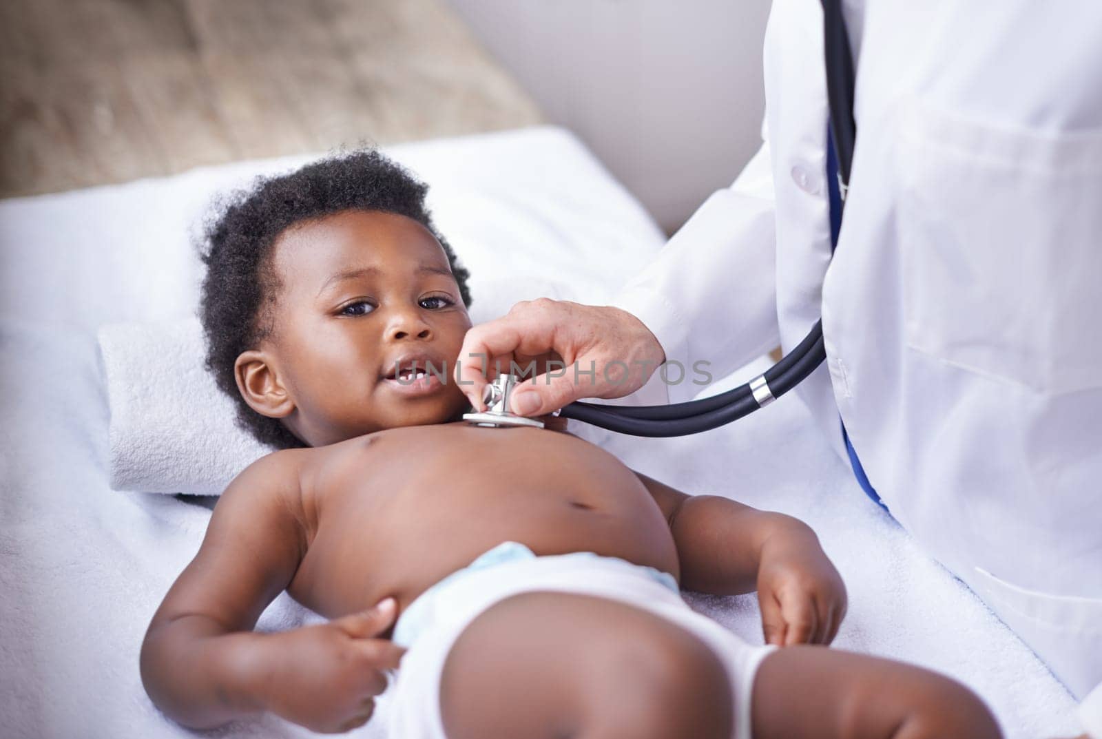 Baby, portrait and pediatrician with stethoscope for heartbeat consultation or lung infection, listening or checkup. Child, boy and face on hospital bed or healthcare wellness in Kenya, clinic or ill by YuriArcurs