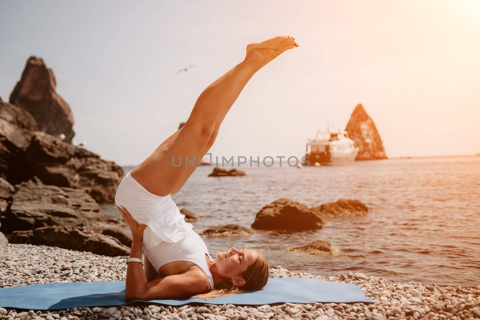 Woman sea yoga. Two happy women practicing yoga on the beach with ocean and rock mountains. Motivation and inspirational fit and exercising. Healthy lifestyle outdoors in nature, fitness concept. by panophotograph