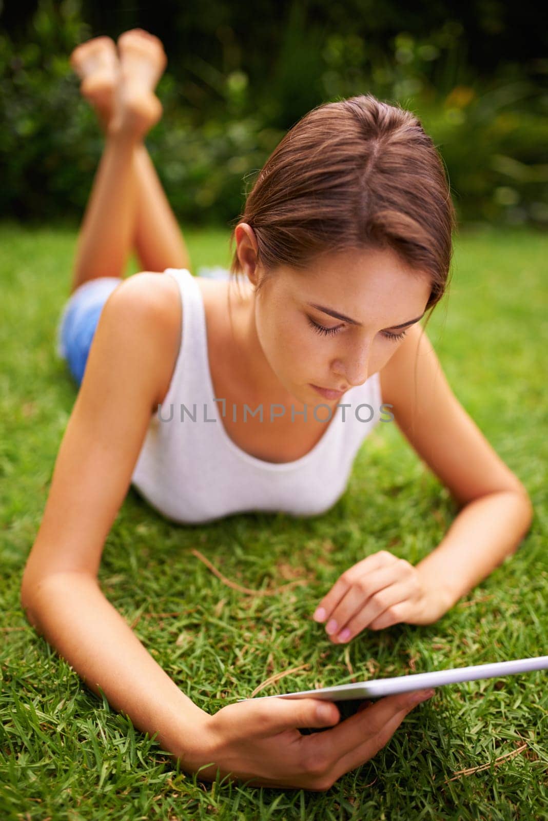 Park, grass and woman relax with tablet, backyard, outdoor and garden to chat or text on social media. Summer, nature and girl online with connection to internet to read romance ebook on site of app.