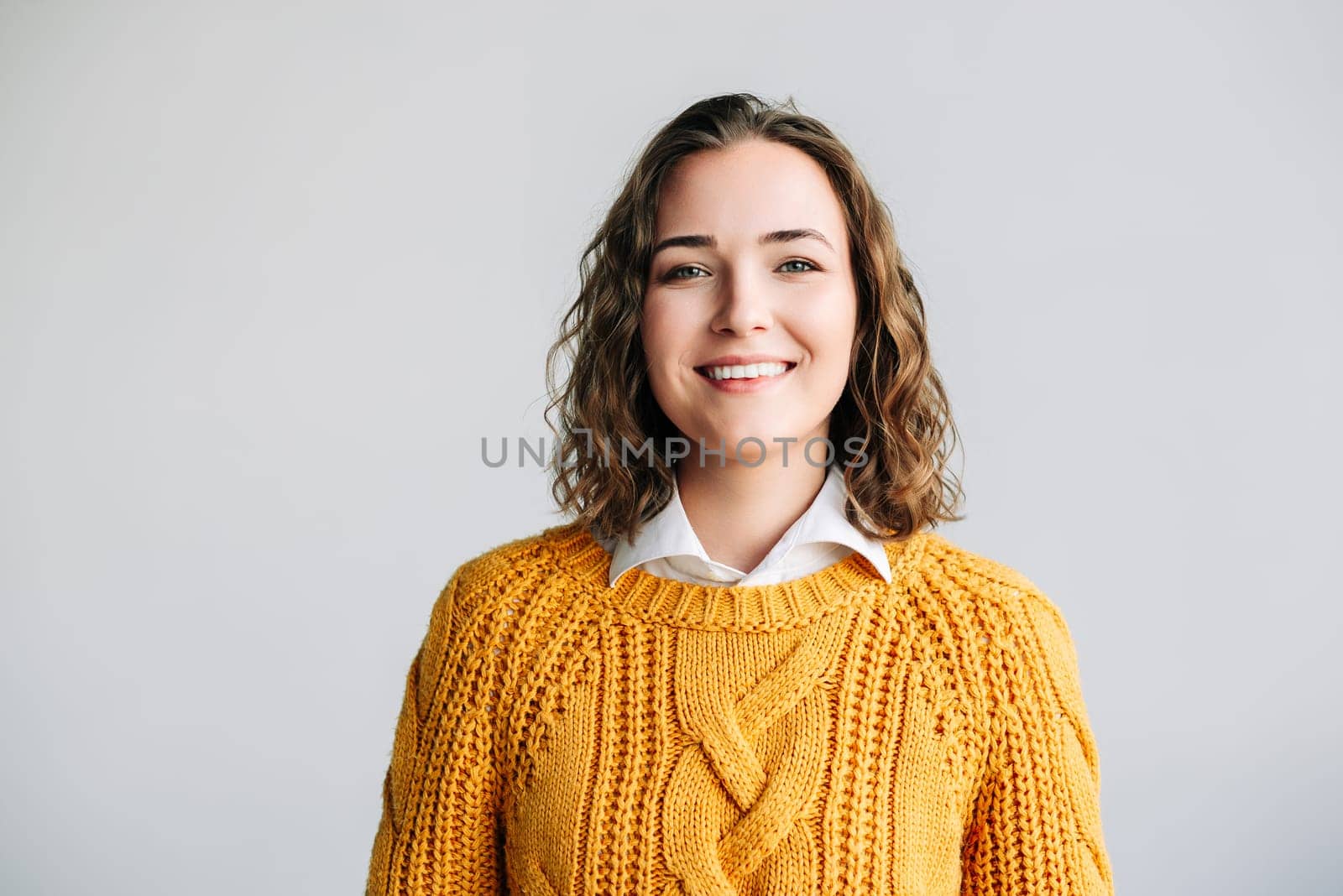 Cheerful Young Woman. Smiling, Positive, and Joyful. Happy Curly-haired Student Laughing, Looking at Camera Isolated on White Background Close-Up Headshot Portrait for Product and Service Advertising