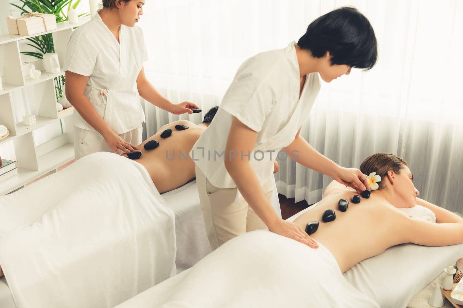 Hot stone massage at spa salon in luxury resort. Quiescent by biancoblue