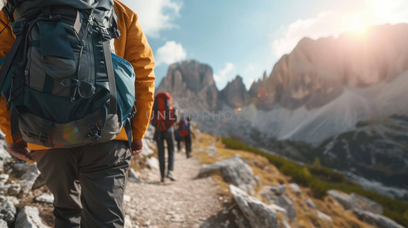 A bunch of backpackers are trekking up the majestic mountain, surrounded by the vast natural landscape, enjoying the sky, plants, and soil along the way. AIG41