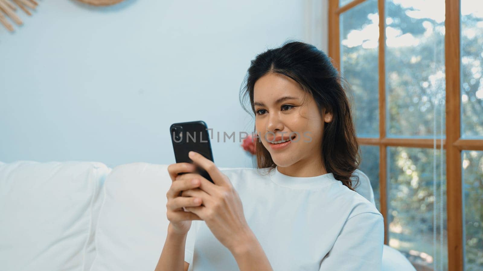 Young woman using smartphone browsing for online shopping E commerce by online payment gateway at vivancy home. Modern and convenience online purchasing make secure and convenient purchases.