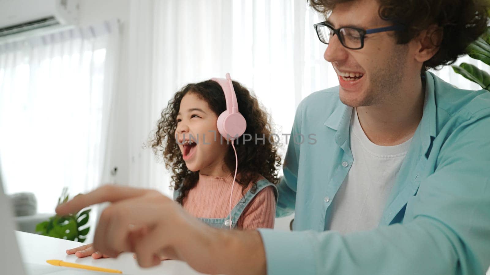 Caucasian dad put headphones on daughter while girl learning code. Father take care schoolgirl while teaching writing engineering prompt and generate Ai by using laptop. Online learning. Pedagogy.