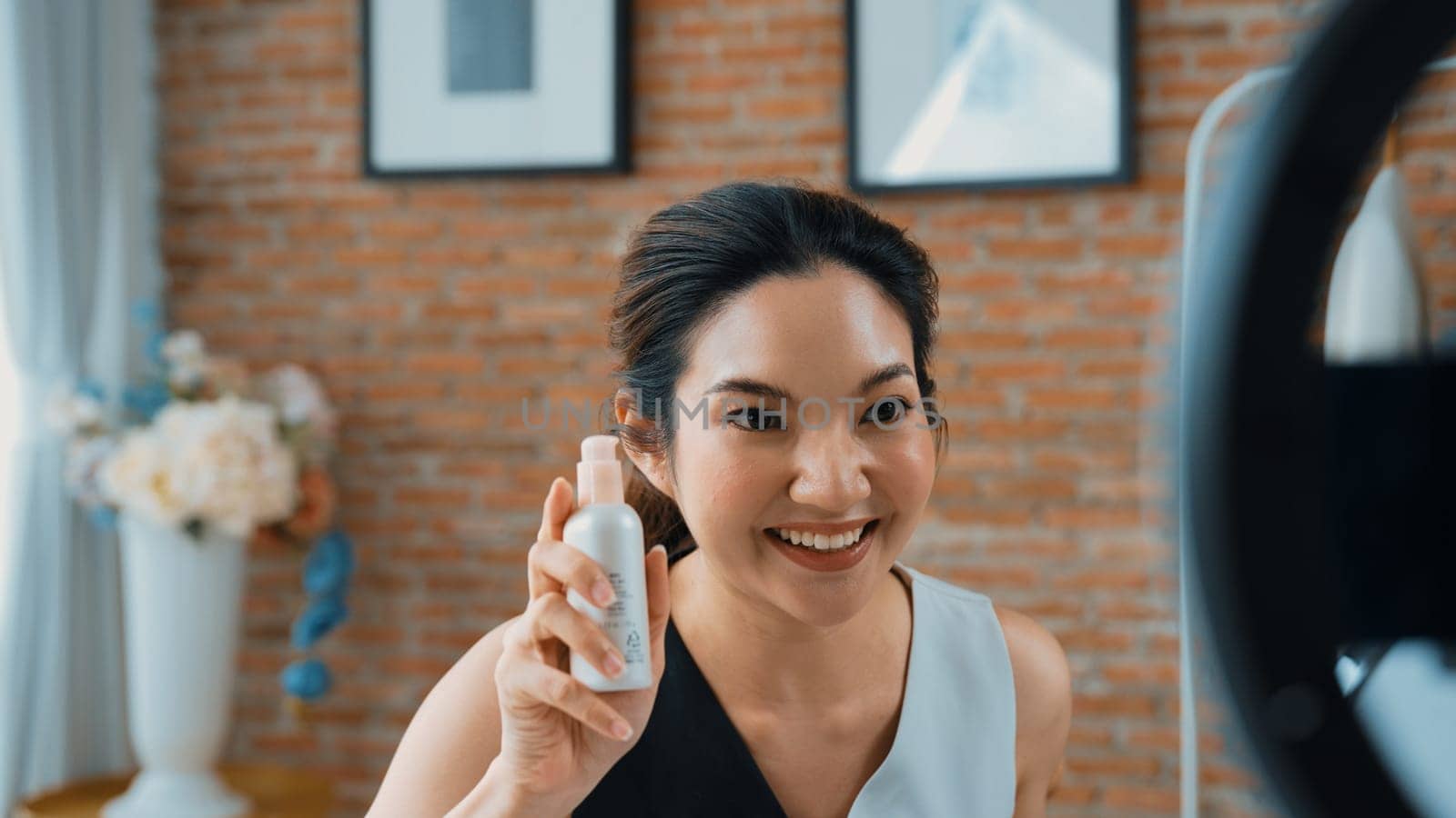 Woman influencer shoot live streaming vlog video review skincare for social media or blog. Happy young girl with vivancy cosmetics studio lighting for marketing recording session broadcasting online.