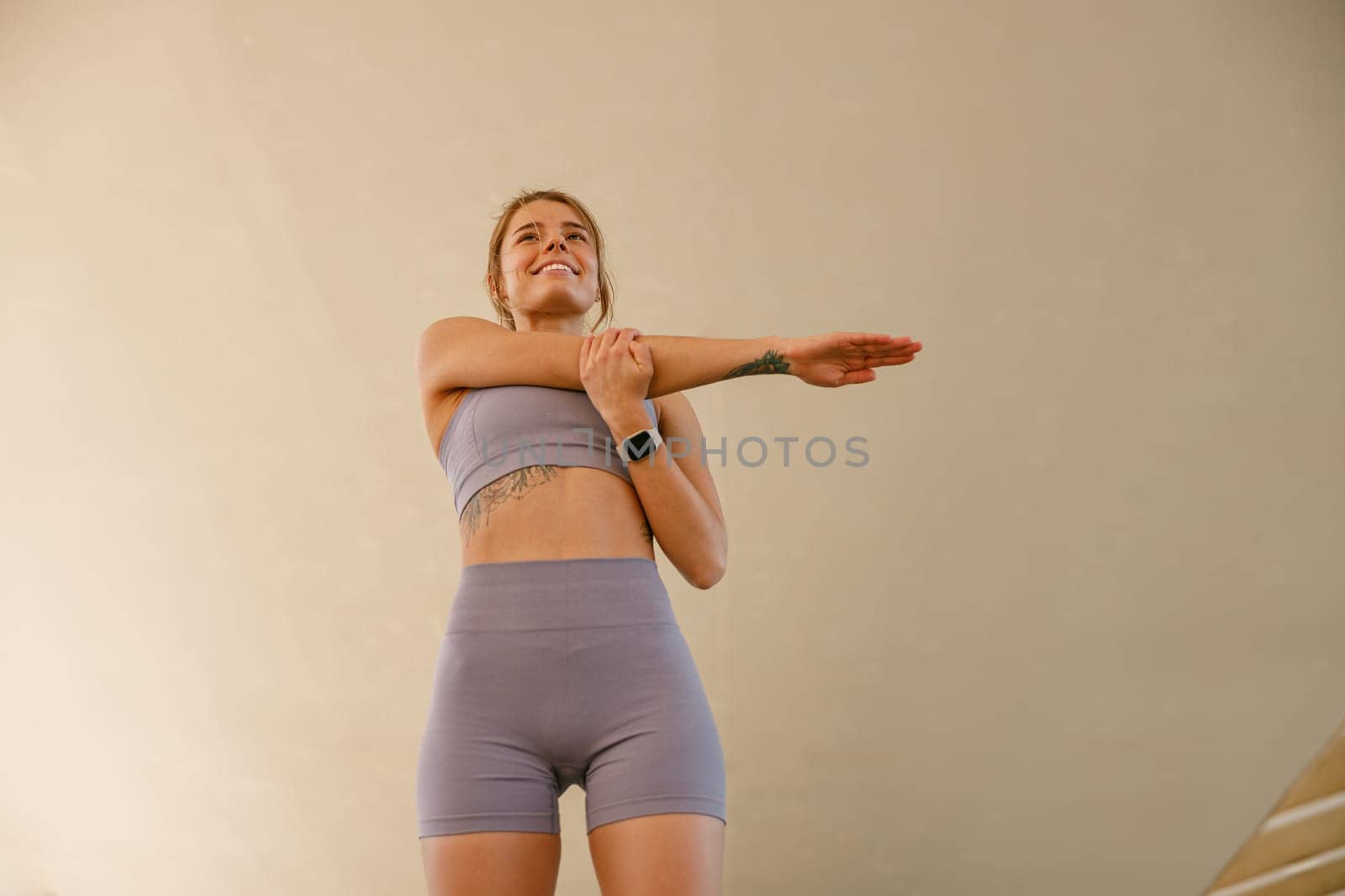 Sporty woman does warm-up exercises in morning before running training outside. Healthy fitness