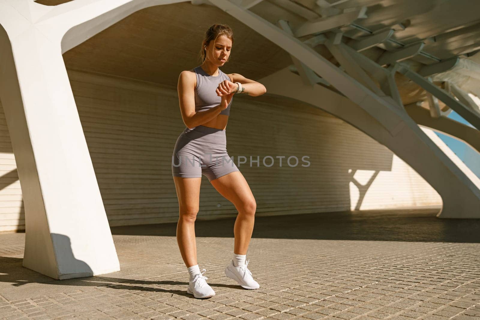 Young fit woman looking at smartwatch and counting calories burned. Healthy life concept by Yaroslav_astakhov