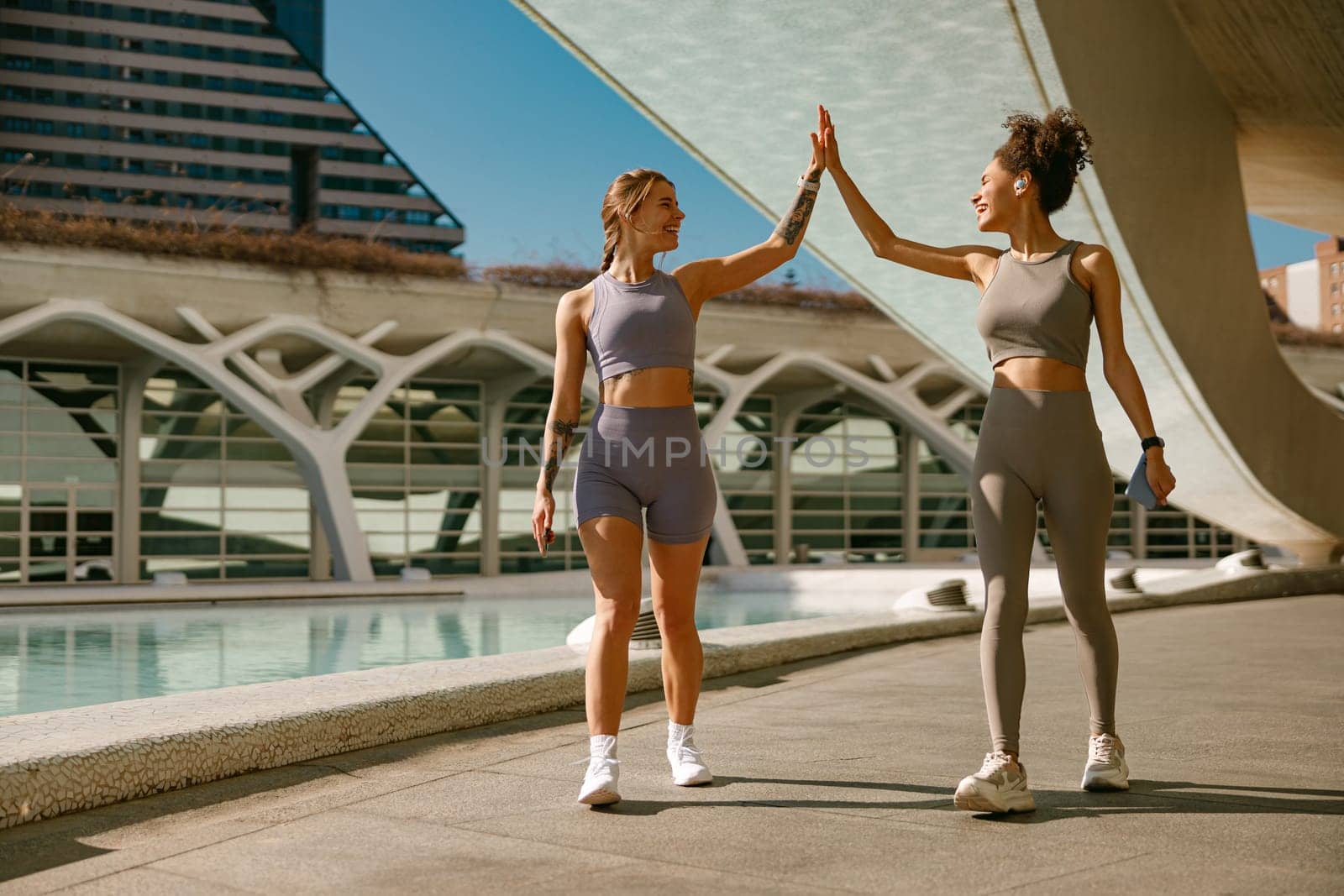 Sporty women greeting together outdoor doing gesture of shake hand after exercising by Yaroslav_astakhov