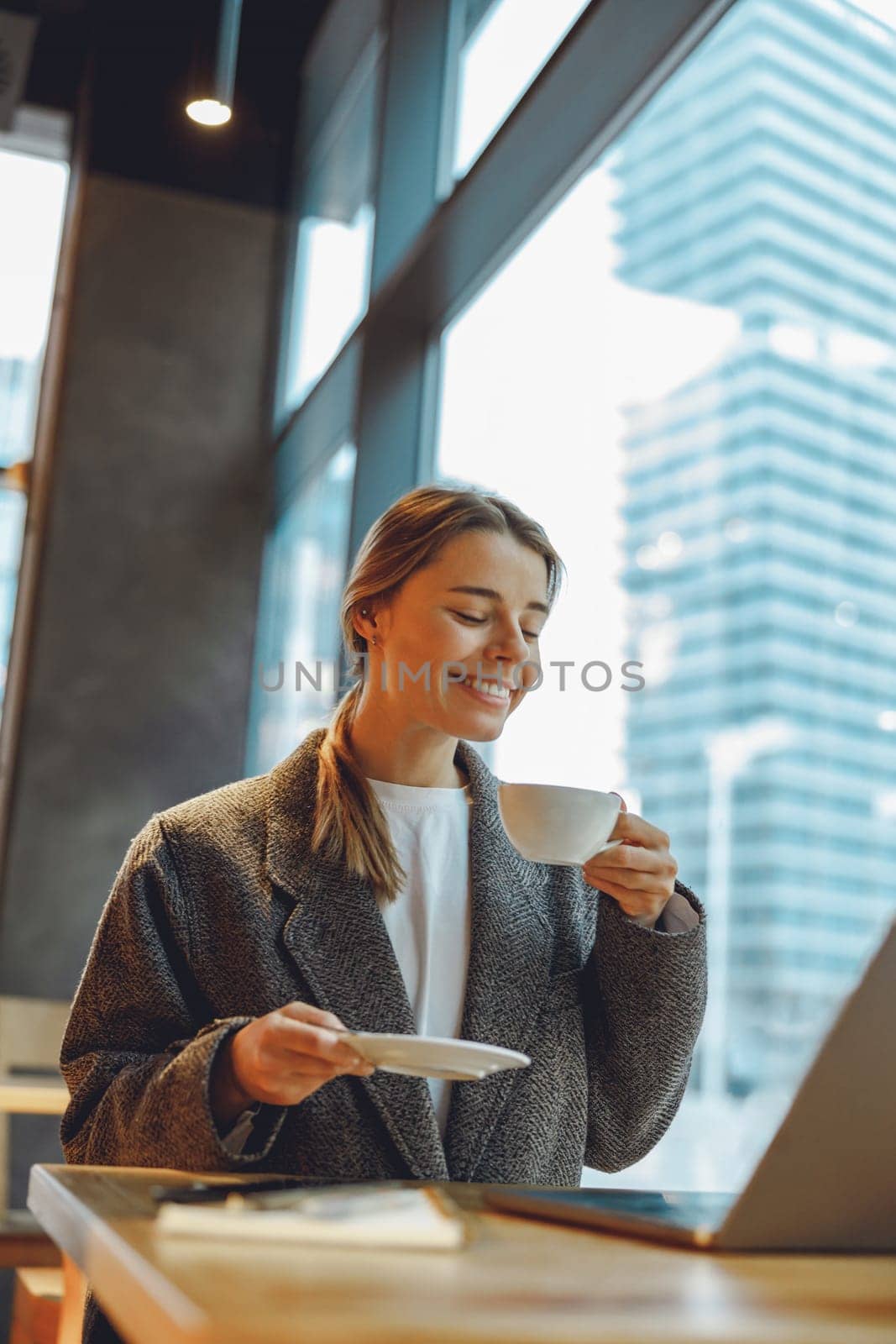 Stylish woman manager freelancer working on laptop while sitting in cozy cafe. High quality photo by Yaroslav_astakhov