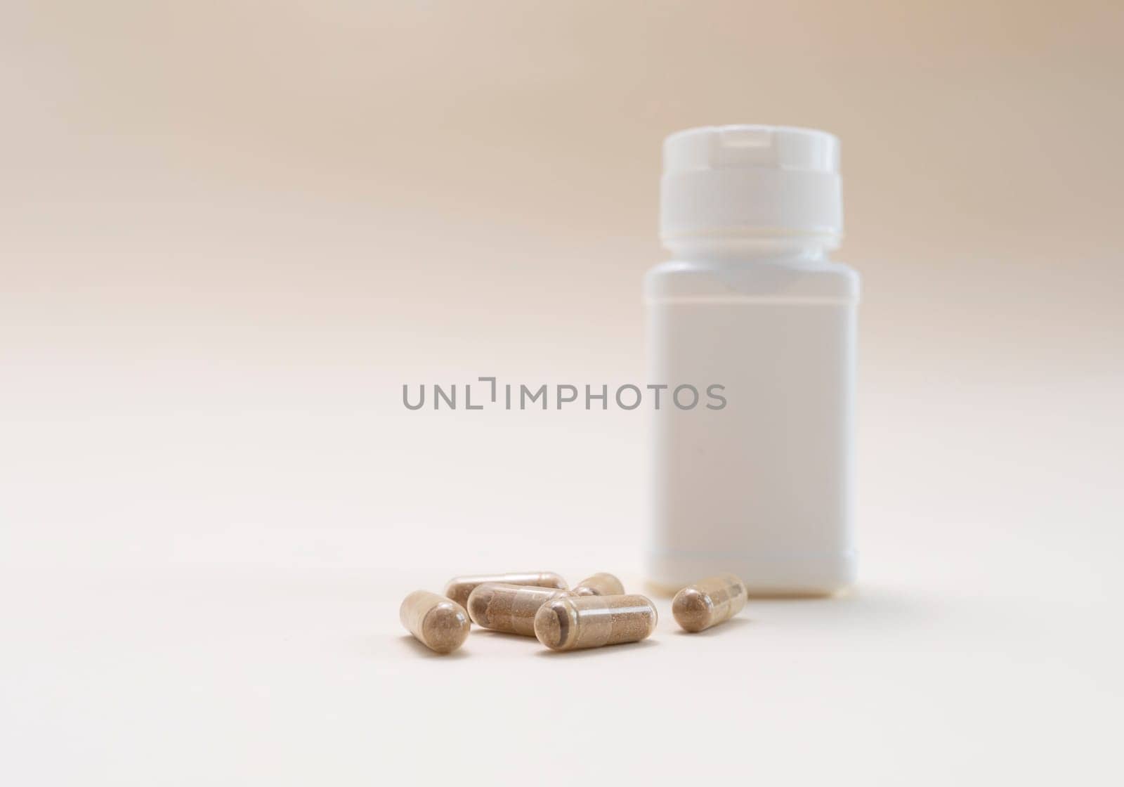 Slippery Elm Pills, Softgels and White Empty Bottle, Container on Beige Background. Mockup Pharmacy. Copy Space For Text. Horizontal Plane. Healthy Lifestyle. Probiotic. High quality photo