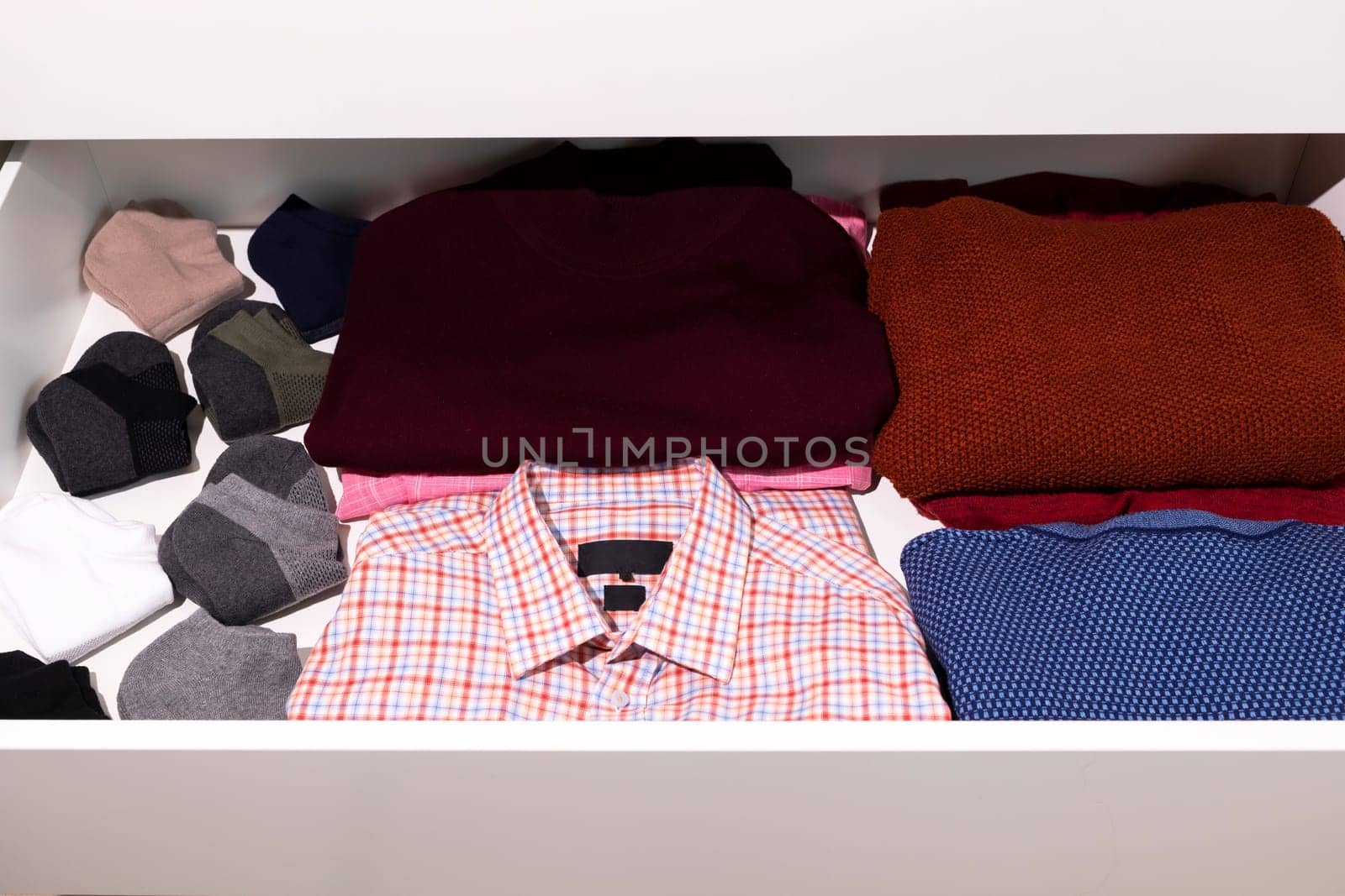 Shelf With Male Warm Clothes, Outfit in Drawer Of Closet. Folded Fresh Shirt, Sweaters, Socks. Man's Clothing Storage. Wardrobes And Cabinetry. National Clean Your Room Day. Horizontal Plane