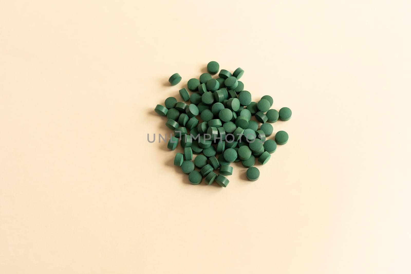Flat Lay Vitamin, Easy To Swallow Green Pills Of Natural Spirulina On Beige Background. They Are Made Of Blue-green Algae With Strong Antioxidant Effects. Horizontal. by netatsi