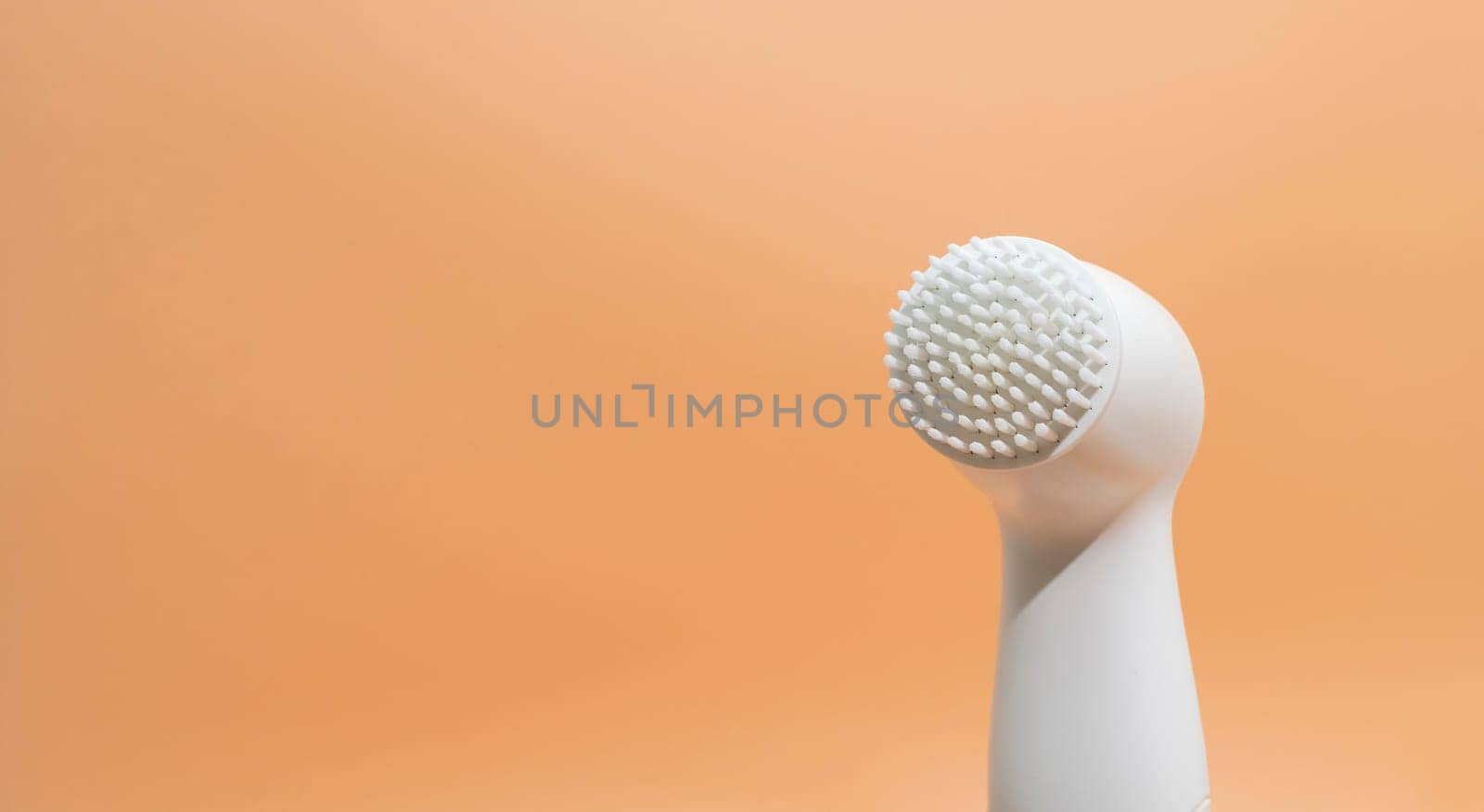 Design Electrical Deep Cleansing Face Brush On Peach Orange Background. Copy Space For Text. Deep Cleansing Facial Remove Makeup. Skin Care Technology. Horizontal Banner High quality photo