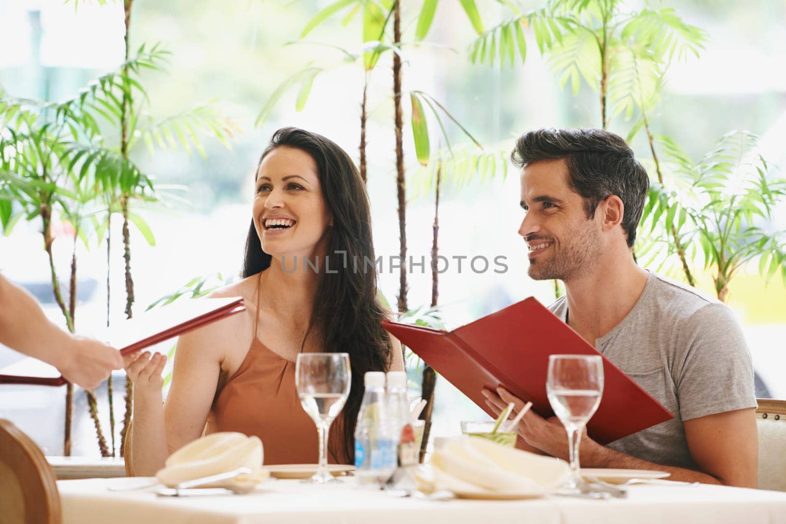 Couple, restaurant and menu with lunch, romance and love for anniversary or celebration. Woman, man and date with luxury, fine dining and smile for relationship on holiday or vacation with meal.
