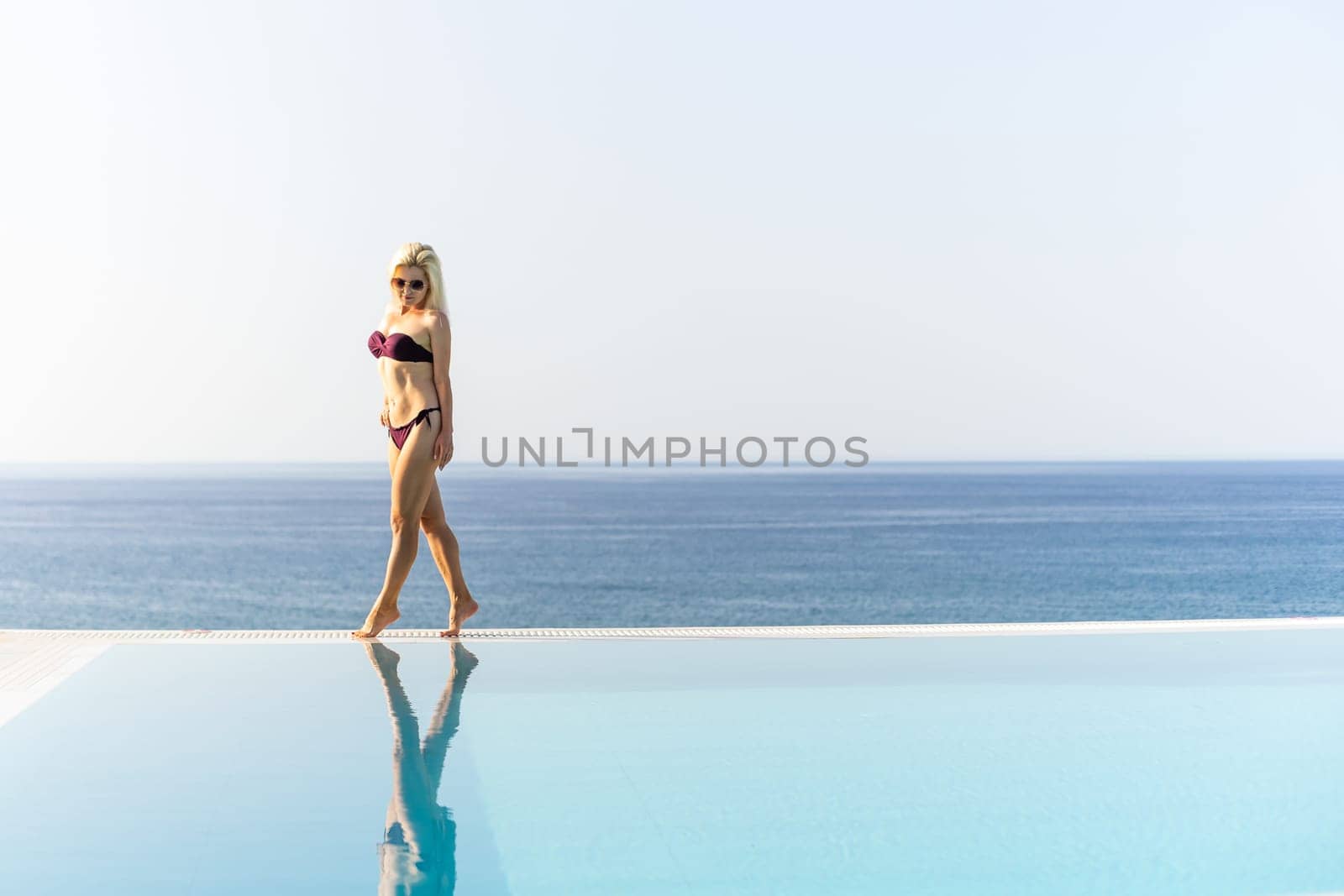 woman near the pool. By Swimming Pool On Travel Holidays Vacation. Beauty, Wellness, Lifestyle