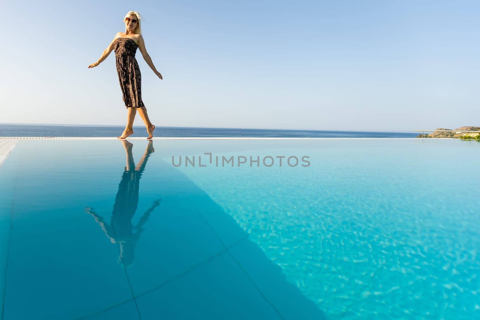 woman near the pool. By Swimming Pool On Travel Holidays Vacation. Beauty, Wellness, Lifestyle