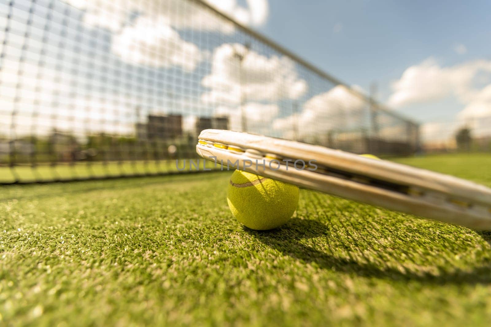 tennis racket with a tennis ball on a tennis court.