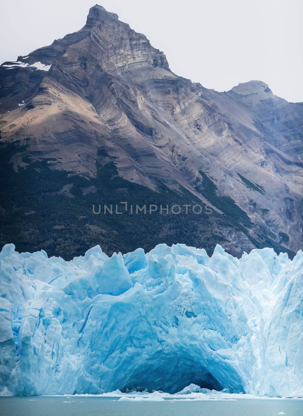 Glacier's vivid blue ice set against a contrasting dark mountain backdrop.