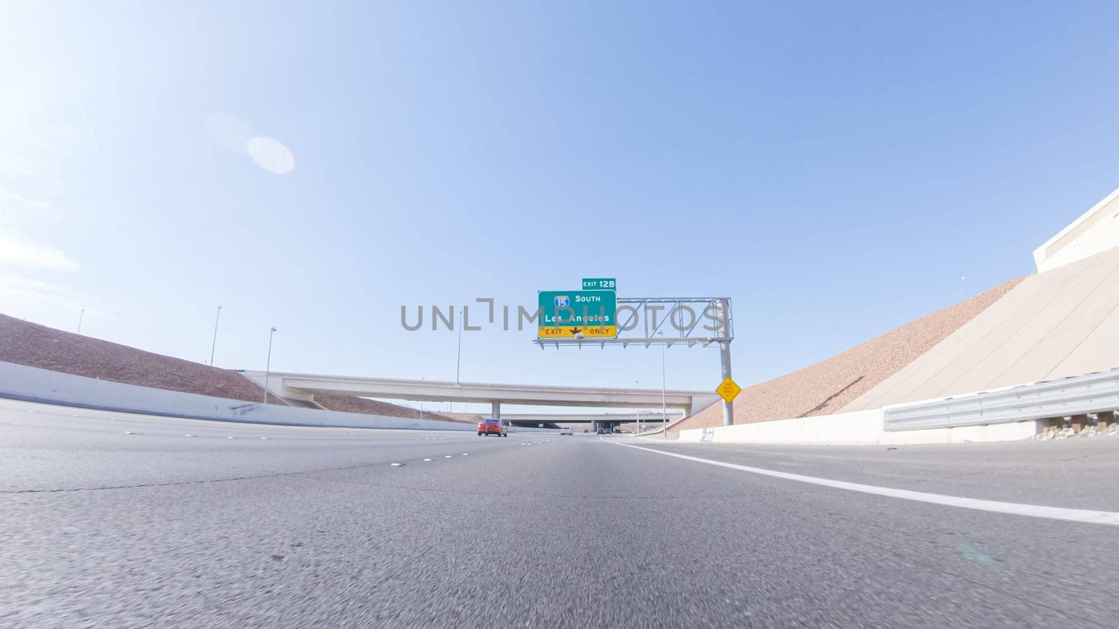 Cruising through Las Vegas in a sleek Tesla vehicle on Highway 15 during the day adds an extra touch of luxury and sustainability to your road trip adventure to California.