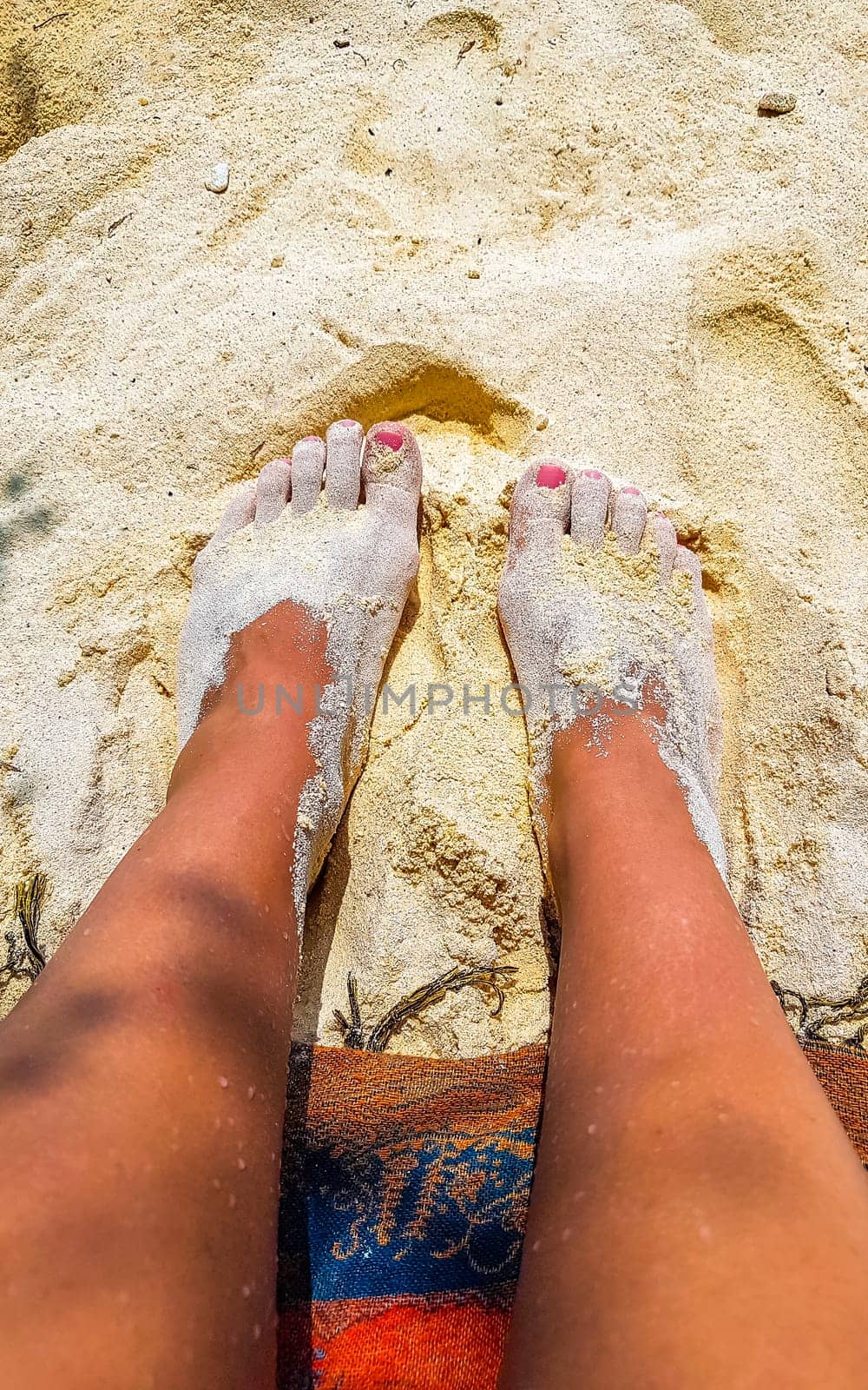 Beautiful sexy female legs on the beach on sand in the water on Rasdhoo island in Rasdhoo Atoll Maldives.