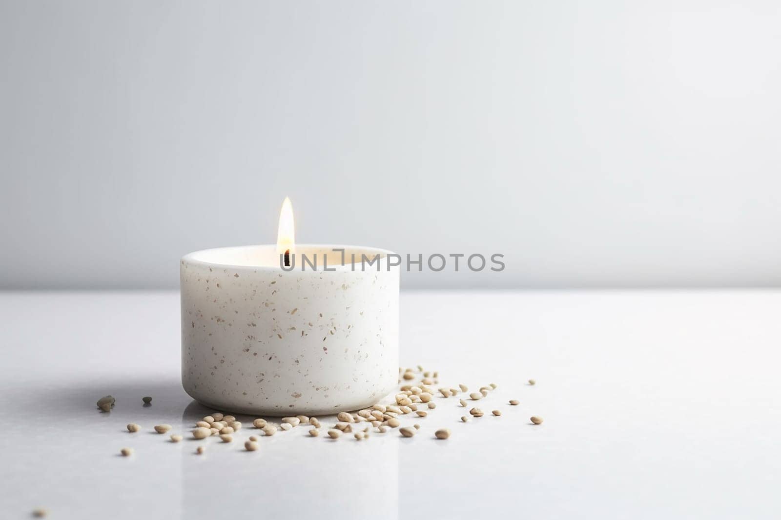 A lit candle in a simple holder surrounded by scattered seeds