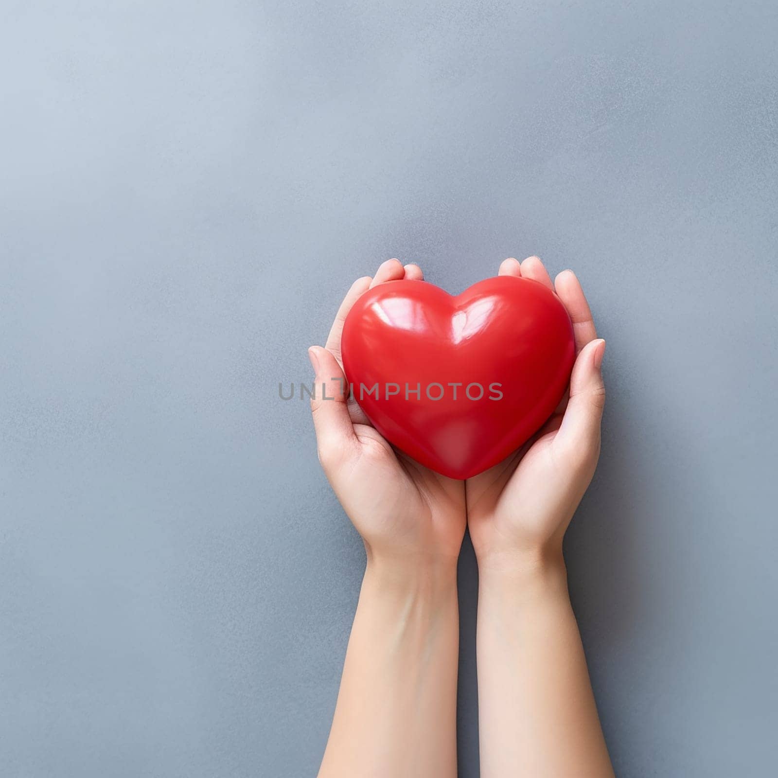 Two hands cradling a red heart against a grey background.