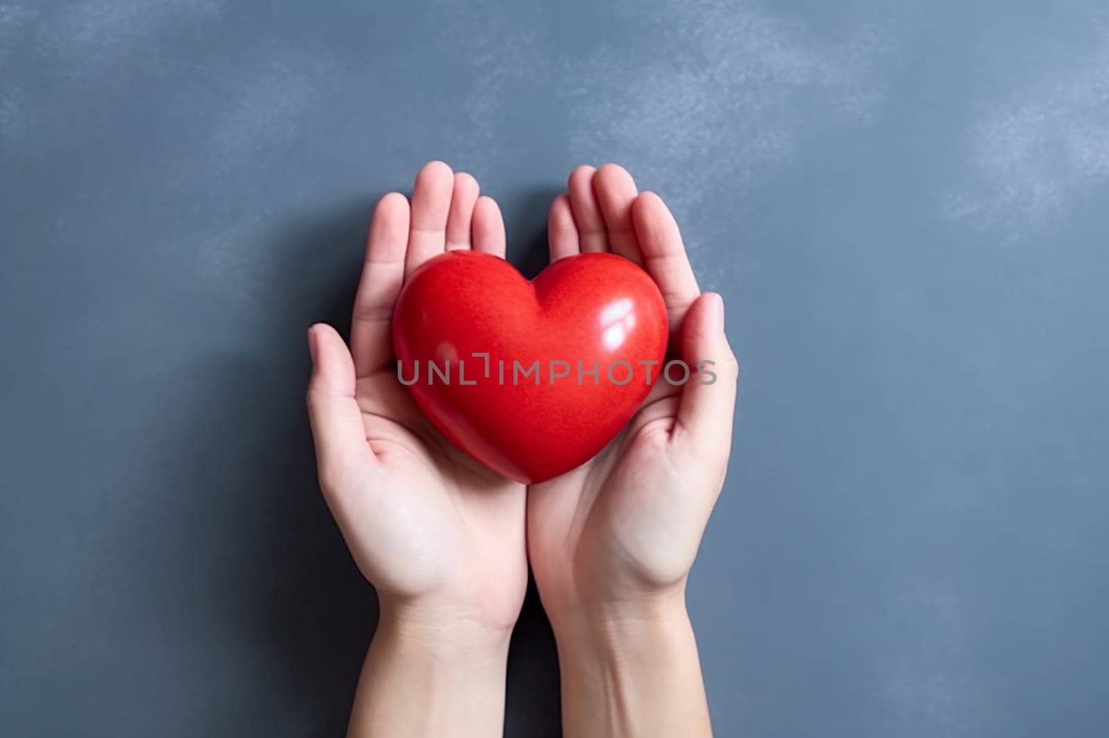 Hands holding a red heart against a grey background
