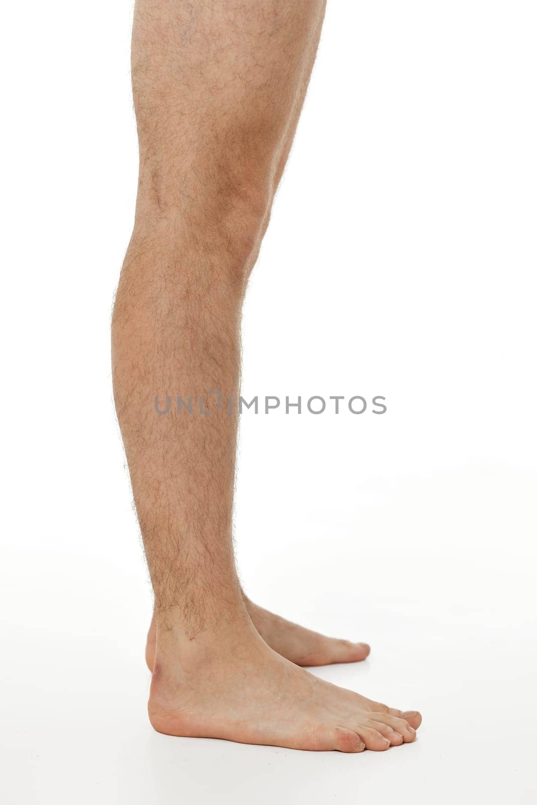 Barefoot male legs on white background. Body care concept.