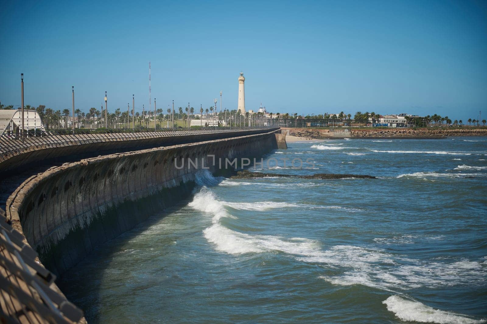 View of sea waves pounding on the headland. lighthouse on the background. Atlantic ocean background. Nature background. Casablanca, Morocco